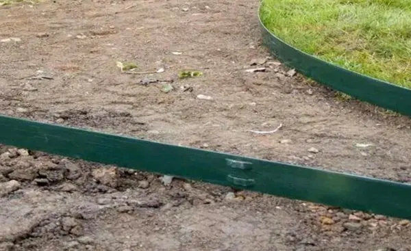 Close-up of two steel edging strips joined with a stake